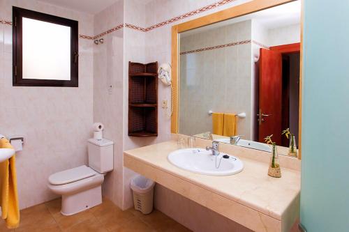 a bathroom with a sink and a toilet and a mirror at SBH Hotel Royal Mónica in Playa Blanca