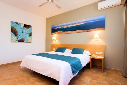 a bedroom with a bed and a painting on the wall at SBH Hotel Royal Mónica in Playa Blanca