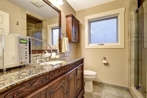 a bathroom with a sink and a toilet and a mirror at Rodee Homestay in West Kelowna