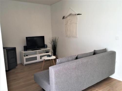 a living room with a couch and a tv at Salty House in Furadouro
