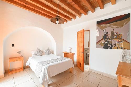 Hotel Meson Cuevano في غواناخواتو: غرفة نوم بسرير ودهان على الحائط