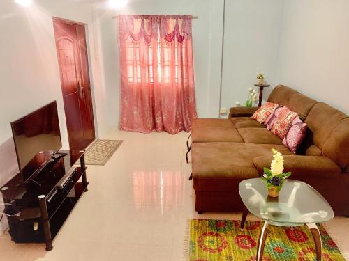 a living room with a couch and a television at Apartment at Trincity Central Road in Port-of-Spain