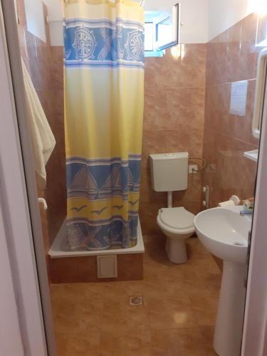 a bathroom with a toilet and a shower curtain at casa andrei m in Eforie Sud