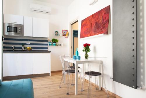 a kitchen with white cabinets and a table and chairs at Sea & Culture - 5 Terre La Spezia in La Spezia