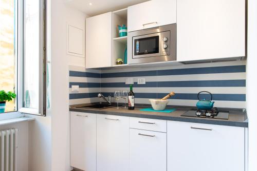 a kitchen with white cabinets and a microwave at Sea & Culture - 5 Terre La Spezia in La Spezia