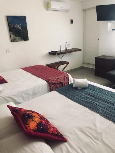 a hotel room with two beds with red pillows at Casa Bizu in Bacalar