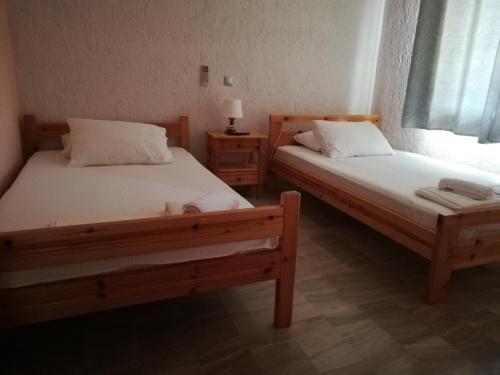 two beds sitting next to each other in a room at Angelos Κandia Apartments in Kandia