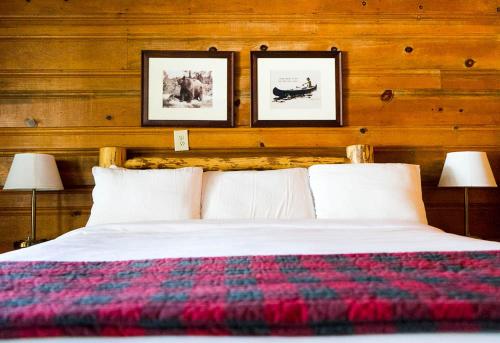 a bedroom with a bed with two pictures on the wall at Shaver Lake Village Hotel in Shaver Lake