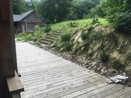 a wooden walkway next to a hill with stairs at Siedlisko U Źródeł in Skierbieszów