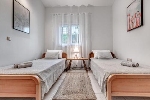 twee bedden in een kamer met een tafel en een raam bij Dream Garden Apartments Corfu in Kommeno