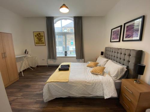 Un dormitorio con una cama grande y una ventana en Self catering Skipton town centre apartment en Skipton