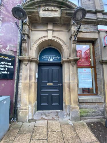 a blue door of a building with a sign on it at Self catering Skipton town centre apartment in Skipton