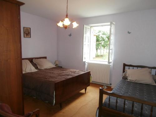 een slaapkamer met een bed en een raam bij La grange de Tombeloly in Clermont-de-Beauregard