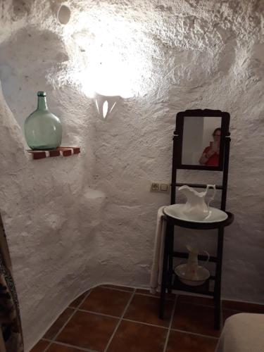 PegalajarにあるCasa Rural Cueva El Sauceのバスルーム(鏡、テーブル、花瓶付)