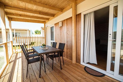 a wooden porch with a table and chairs on a deck at Mediteran Homes with Terme Čatež Tickets in Čatež ob Savi