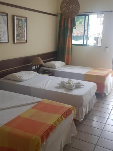 a hotel room with two beds and a window at Hotel Pousada São Francisco in Olinda