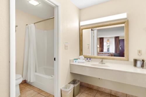La salle de bains est pourvue d'un lavabo, de toilettes et d'un miroir. dans l'établissement Americas Best Value Inn St. Augustine, à Saint Augustine Beach