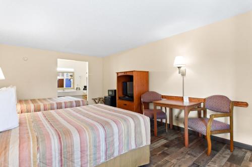 une chambre d'hôtel avec un lit et un bureau dans l'établissement Americas Best Value Inn Ocean Inn, à Saint Augustine Beach