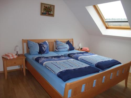 a bedroom with a bed with blue sheets and a window at Ferienhaus Hubertus in Elend mit Balkons in Elend