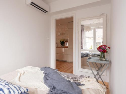 a white bedroom with a bed and a mirror at Esterka in Kazimierz Dolny