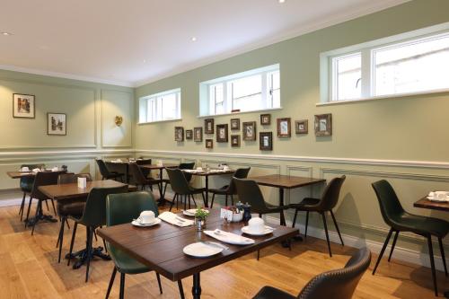 un comedor con mesas, sillas y ventanas en Tyndall Villa Boutique B&B en Bath