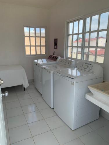 a white laundry room with a washer and dryer at Casa Coral Cozumel in Cozumel
