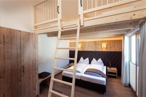 a bedroom with a bunk bed with a ladder at CHALET MONTIS in Flachau