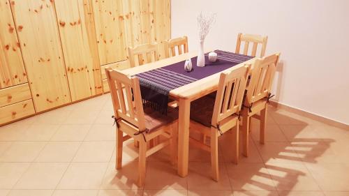 a wooden dining room table and chairs with a blue table cloth at APARTMÁNY POD ČERCHOVEM in Trhanov
