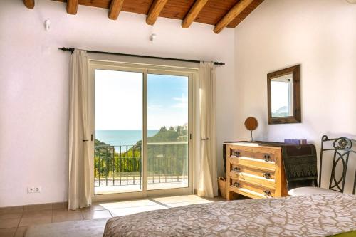 um quarto com uma cama e uma janela com vista em Villa Diane Luxury Cottage Ocean views pool em Benagil