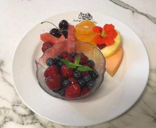 een bord met een fruitschaal op een tafel bij Auberge du Sault-à-la-Puce in Chateau Richer