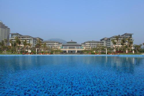 una gran piscina de agua con edificios en el fondo en Crowne Plaza Hailing Island, an IHG Hotel, en Yangjiang