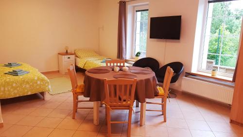 a room with a table and chairs and a bedroom at APARTMÁNY POD ČERCHOVEM in Trhanov