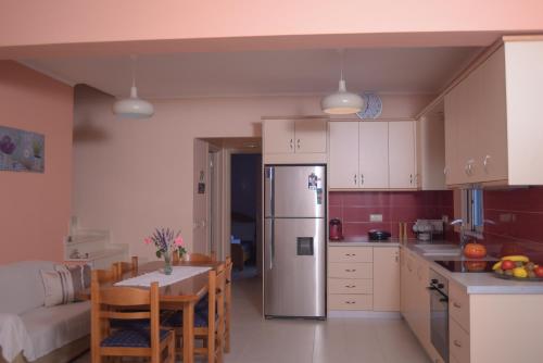 a kitchen with a refrigerator and a table in it at Elina's Maisonette in Episkopos