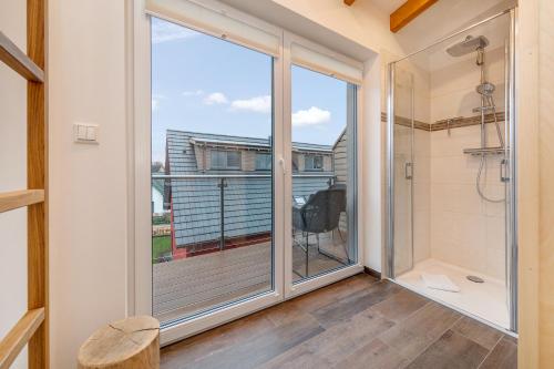 a bathroom with a shower and a large window at Suite Strandluft in Zingst