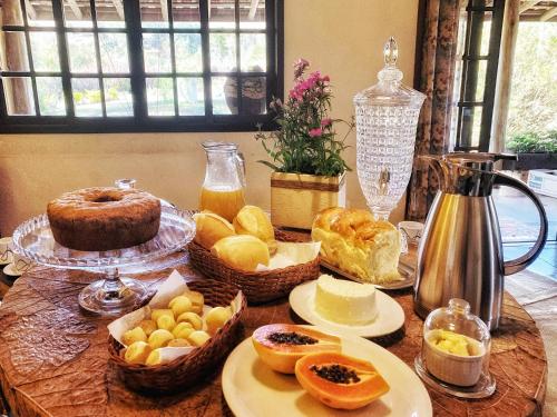 une table avec du pain et d'autres aliments dessus dans l'établissement Recanto Roça Grande, à Cunha