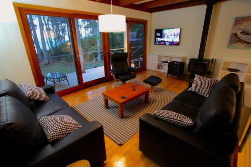 a living room with two couches and a table at Beachgum in Sunshine Bay