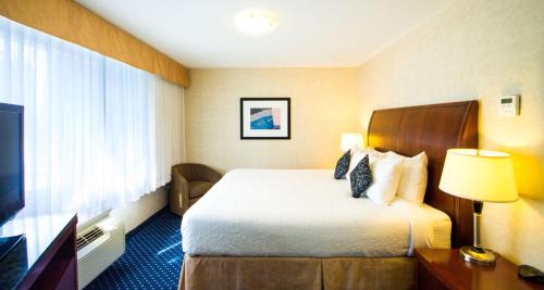 a hotel room with a bed and a television at Best Western Plus Suites Downtown Calgary in Calgary