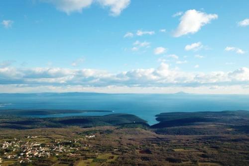 an aerial view of the ocean and a city at Infinity pool Villa San Amore in Divšići