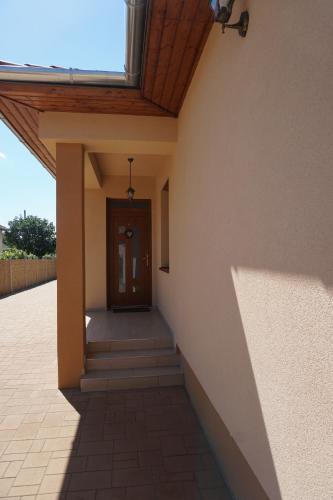 a hallway of a building with a door and stairs at Boróka 2 Vendégház in Szentes