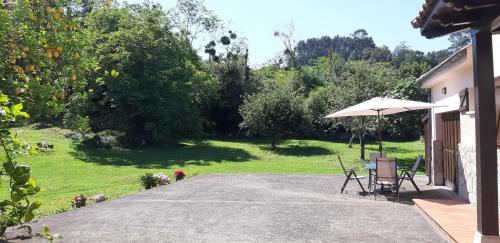 a patio with an umbrella and a table and chairs at LAS ATAZADAS in Villanueva de Pría