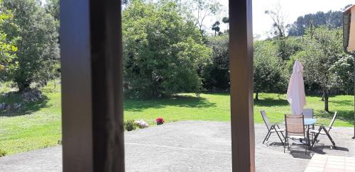 a patio with a table and chairs and an umbrella at LAS ATAZADAS in Villanueva de Pría