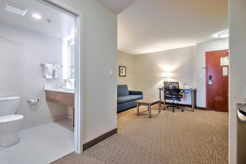 Comfort Inn & Suites South في كالغاري: حمام مع مرحاض ومغسلة وأريكة