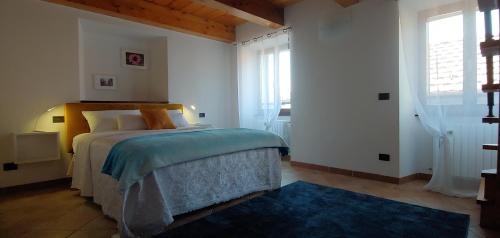 a bedroom with a bed with a blue rug at CasAle sul Lago di Como in Blevio