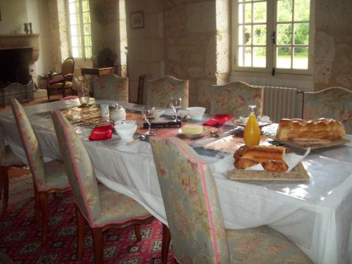 une table avec un chiffon de table blanc et de la nourriture dans l'établissement Château Le Guit, à Grignols