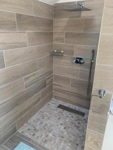 a bathroom with a shower with brown tile at Log cabin in Coventry