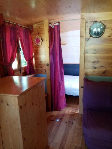 une chambre avec un lit dans une cabane en bois dans l'établissement Camping La Bergerie, à La Chapelle-Achard
