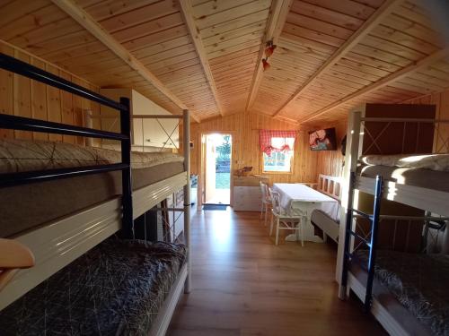 Zimmer mit 2 Etagenbetten und einem Tisch in der Unterkunft Ferienhäuschen MD Sportfiske in Sveg