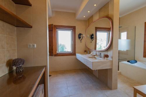La salle de bains est pourvue d'un lavabo, d'un miroir et d'une baignoire. dans l'établissement Quinta da Colina, à Évora