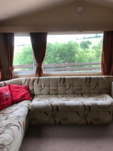 a couch sitting in front of a large window at Ferienhaus Chilllout Chalets Daun-Kradenbach in Kradenbach