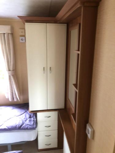 a closet with a cabinet and a bed in a room at Ferienhaus Chilllout Chalets Daun-Kradenbach in Kradenbach